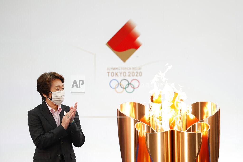 Kim Kyung-Hoon Tokyo 2020 Organizing Committee President Seiko Hashimoto applauds next to the celebration cauldron on the first day of the Tokyo 2020 Olympic torch relay in Naraha, Fukushima prefecture, northeastern Japan, Thursday, March 25, 2021. The torch relay for the postponed Tokyo Olympics began its 121-day journey across Japan on Thursday and is headed toward the opening ceremony in Tokyo on July 23. (Kim Kyung-Hoon/Pool Photo via AP)