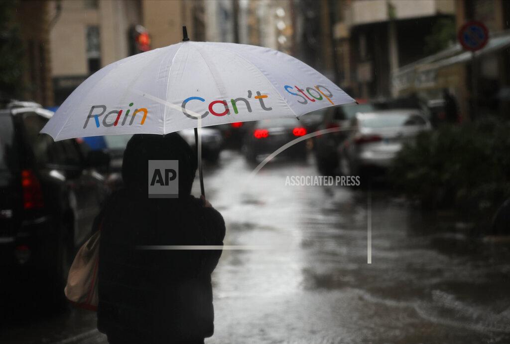 Hussein Malla A woman holds her umbrella as she crosses a street, in Beirut, Lebanon, Wednesday, Feb. 17, 2021. Breaking a warm spell, Storm Joyce that hit Lebanon brought heavy rainfall, a sharp drop in temperatures and the heaviest snow fall in Lebanon this year. (AP Photo/Hussein Malla)