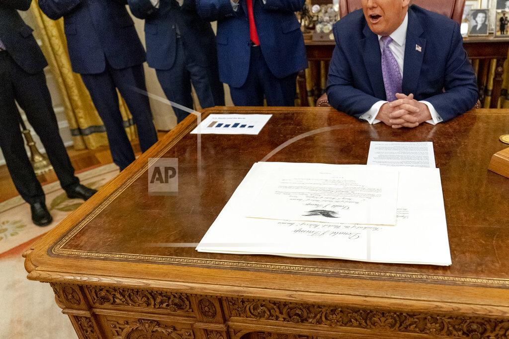 Andrew Harnik President Donald Trump sits in front of documents in the Oval Office at the White House, Wednesday, Aug. 12, 2020, in Washington. Trump said on Thursday that the United Arab Emirates and Israel have agreed to establish full diplomatic ties as part of a deal to halt the annexation of occupied land sought by the Palestinians for their future state. (AP Photo/Andrew Harnik)