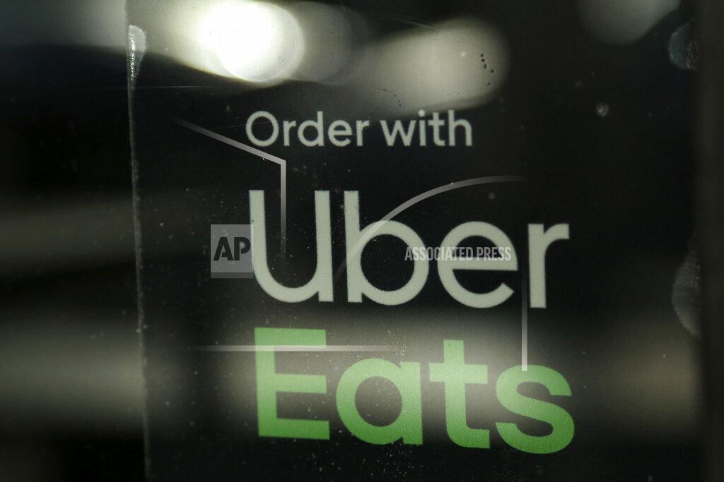 Lynne Sladky FILE - In this Nov. 6, 2019, file photo, a restaurant advertises Uber Eats in the Coconut Grove neighborhood in Miami. In 2020, many people took to working remotely in sweatpants, hopped onto an expensive high-tech exercise bike and had their favorite restaurant dish delivered, perhaps by a driver trying to earn an extra buck and hoping not to catch the coronavirus.(AP Photo/Lynne Sladky, File)