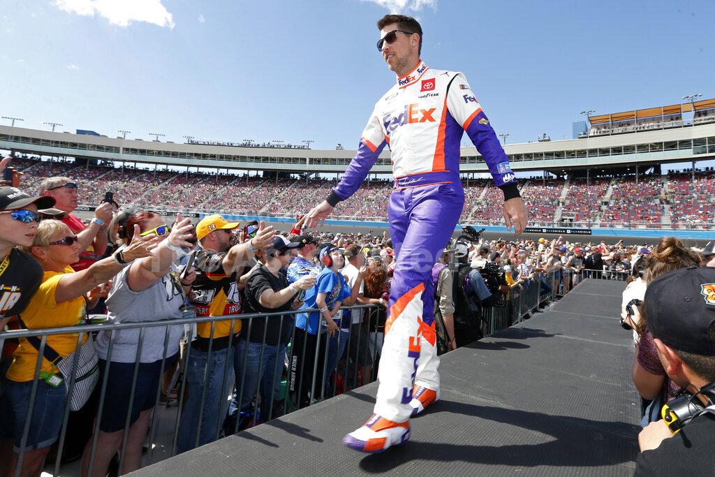 FILE- In this March 8, 2020, file photo, Denny Hamlin walks out during driver introductions prior to the NASCAR Cup Series auto race at Phoenix Raceway in Avondale, Ariz. Hamlin is 0-for-3 in championship chances, his shot at an elusive first NASCAR crown ending just short of the finish line all three times he’s been close. It’s his turn again, without rival Kevin Harvick in his way in Sunday's season finale at Phoenix Raceway. (AP Photo/Ralph Freso, File)