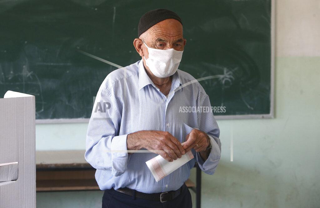 Boris Grdanoski An elderly ethnic Albanian man wearing face mask to protect from coronavirus, votes in the parliamentary elections in polling station in Skopje, North Macedonia, Wednesday, July 15, 2020. Voters in North Macedonia headed to the polls on Wednesday in the country's general election despite an alarming spike in coronavirus cases in the tiny Balkan nation. (AP Photo/Boris Grdanoski)