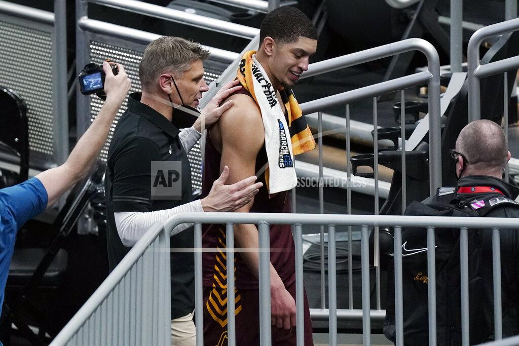Mark Humphrey Loyola of Chicago head coach Porter Moser walks off the court with Lucas Williamson after beating Illinois in a college basketball game in the second round of the NCAA tournament at Bankers Life Fieldhouse in Indianapolis Sunday, March 21, 2021. Loyola upset Illinois 71-58. (AP Photo/Mark Humphrey)