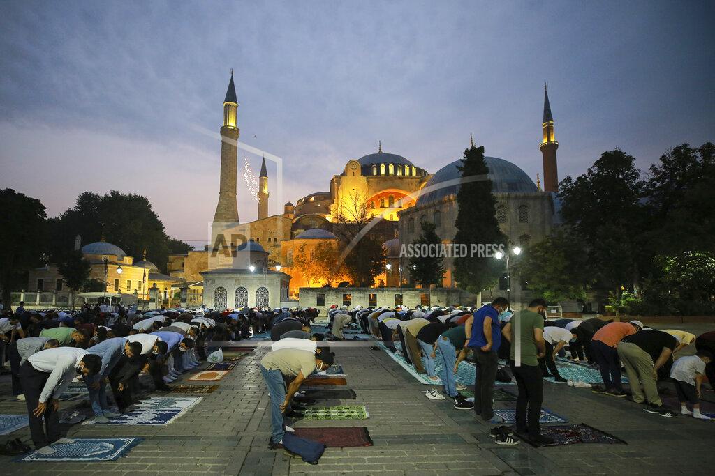 Mucahid Yapici Muslims offer prayers during the first day of Eid al-Adha, outside the iconic Haghia Sophia in the historic Sultan Ahmed district of Istanbul, Tuesday, July 20, 2021. Thousands of Muslims attended dawn Eid al-Adha prayers in Istanbul. (AP Photo/Mucahid Yapici)