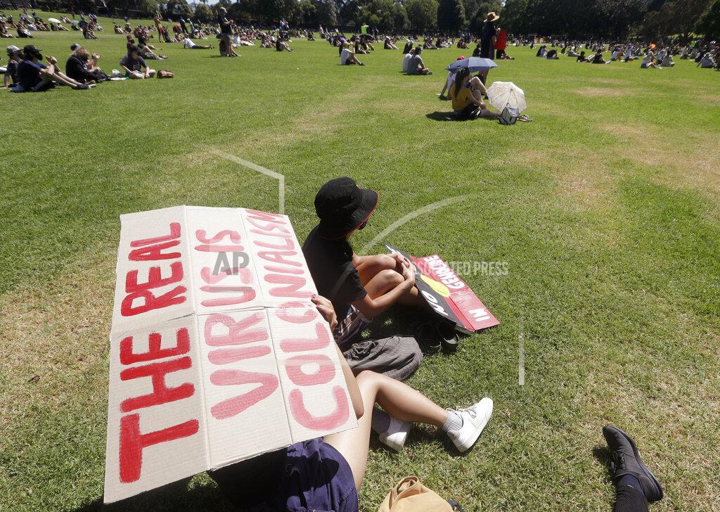 Rick Rycroft A protester holds a sign in a social distanced crowd during an Aboriginal-lead Invasion Day rally on Australia Day in Sydney, Tuesday, Jan. 26, 2021. Many of Australia's First Nations people say that sovereignty has never been ceded and oppose ongoing colonial violence and destruction. (AP Photo/Rick Rycroft)