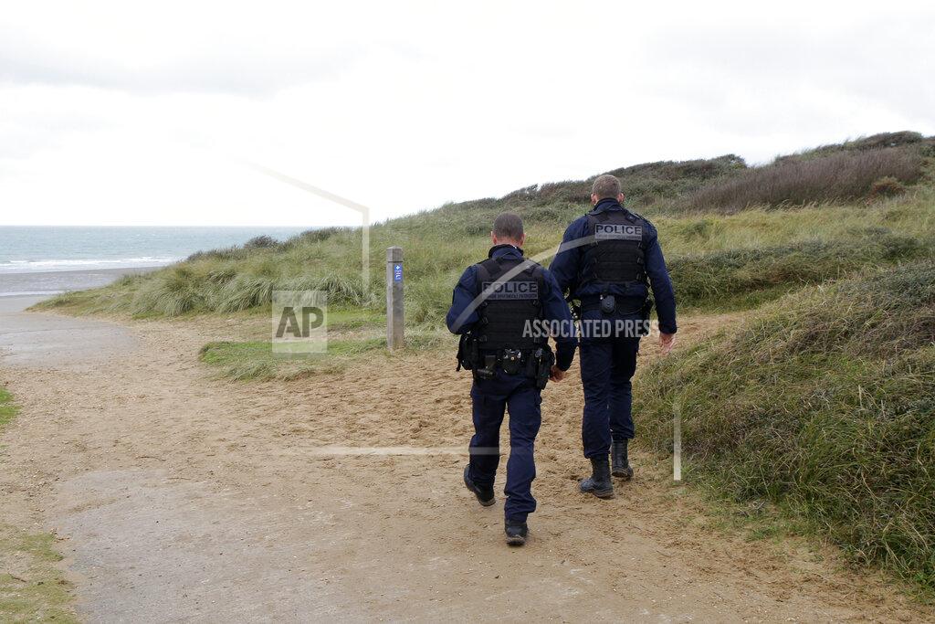 Michel Spingler French police officers patrol on the dunes in Wimereux, northern France, Thursday, Nov. 25, 2021 in Calais, northern France. Children and pregnant women were among at least 27 migrants who died when their small boat sank in an attempted crossing of the English Channel, a French government official said Thursday. French Interior Minister Gerald Darmanin also announced the arrest of a fifth suspected smuggler thought to have been involved in what was the deadliest migration tragedy to date on the dangerous sea lane.(AP Photo/Michel Spingler)