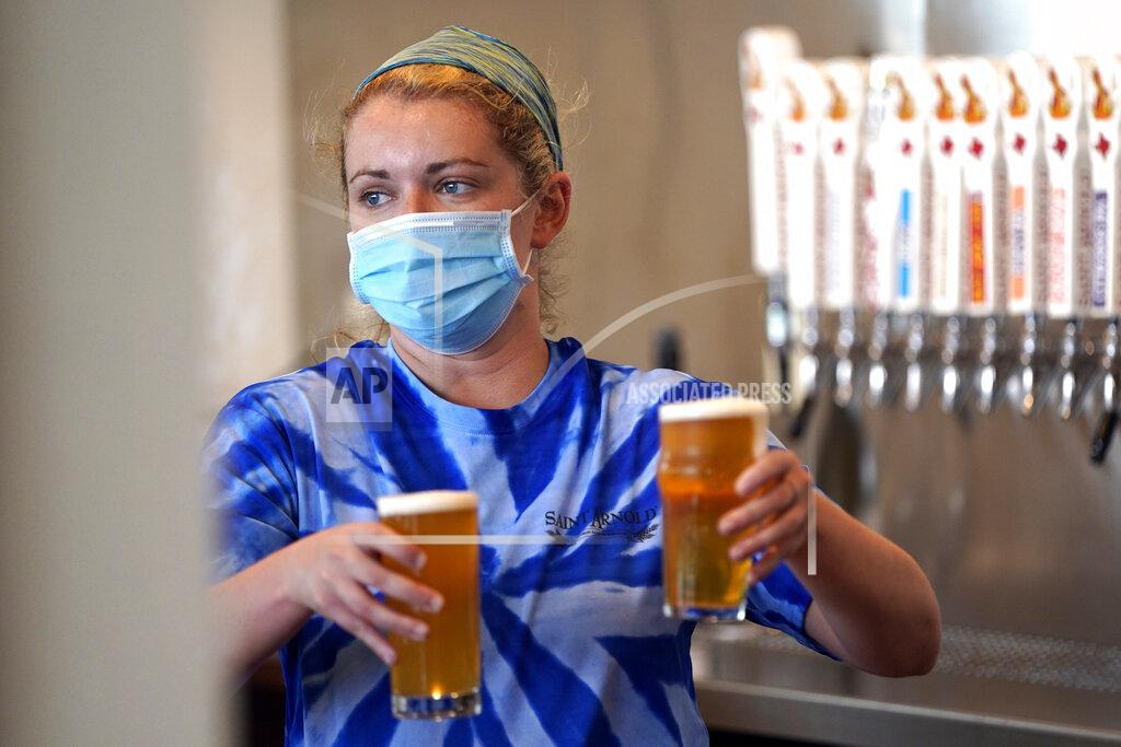 David J. Phillip Bartender Katie McGranahan serves beers at the Saint Arnold Brewing Company, Friday, June 26, 2020, in Houston. Texas Gov. Greg Abbott announced Friday that he is shutting bars back down and scaling back restaurant capacity to 50%, in response to the increasing number of COVID-19 cases in Texas. (AP Photo/David J. Phillip)