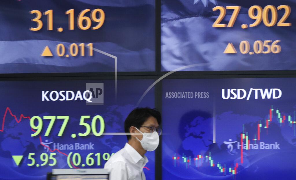 Lee Jin-Man A currency trader walks near screens showing the Korean Securities Dealers Automated Quotations (KOSDAQ), left bottom, and the foreign exchange rates at a bank's foreign exchange dealing room in Seoul, South Korea, Monday, May 3, 2021. Shares were mostly lower in Asia in thin trading Monday, with many markets including those in Tokyo and Shanghai closed for holidays. (AP Photo/Lee Jin-man)