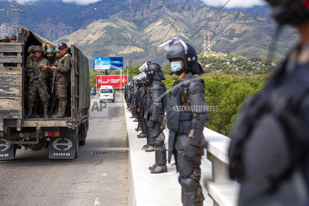 Oliver De Ros Guatemalan soldiers stands guard at a police checkpoint on the Motagua River to stop the advance of Honduran migrants in Zacapa, Guatemala, Tuesday, Jan. 19, 2021. A once large caravan of Honduran migrants that pushed its way into Guatemala last week had dissipated by Tuesday in the face of Guatemalan security forces. (AP Photo/Oliver de Ros)