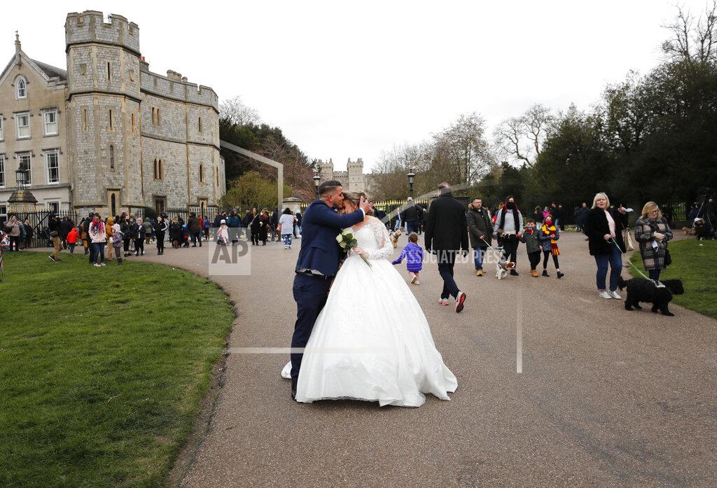 Frank Augstein A newlywed couple kiss outside the gates of Windsor Castle, a day after the death of Britain's Prince Philip, in Windsor, England, Saturday, April 10, 2021. Britain's Prince Philip, the irascible and tough-minded husband of Queen Elizabeth II who spent more than seven decades supporting his wife in a role that mostly defined his life, died on Friday. (AP Photo/Frank Augstein)