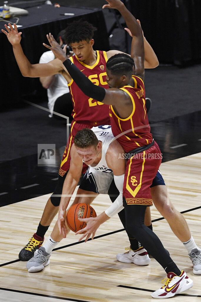 Jessica Hill BYU's Kolby Lee, center, struggles between the defense of Southern California's Max Agbonkpolo, left, and Southern California's Chevez Goodwin, right, in the first half of an NCAA college basketball game, Tuesday, Dec. 1, 2020, in Uncasville, Conn. (AP Photo/Jessica Hill)