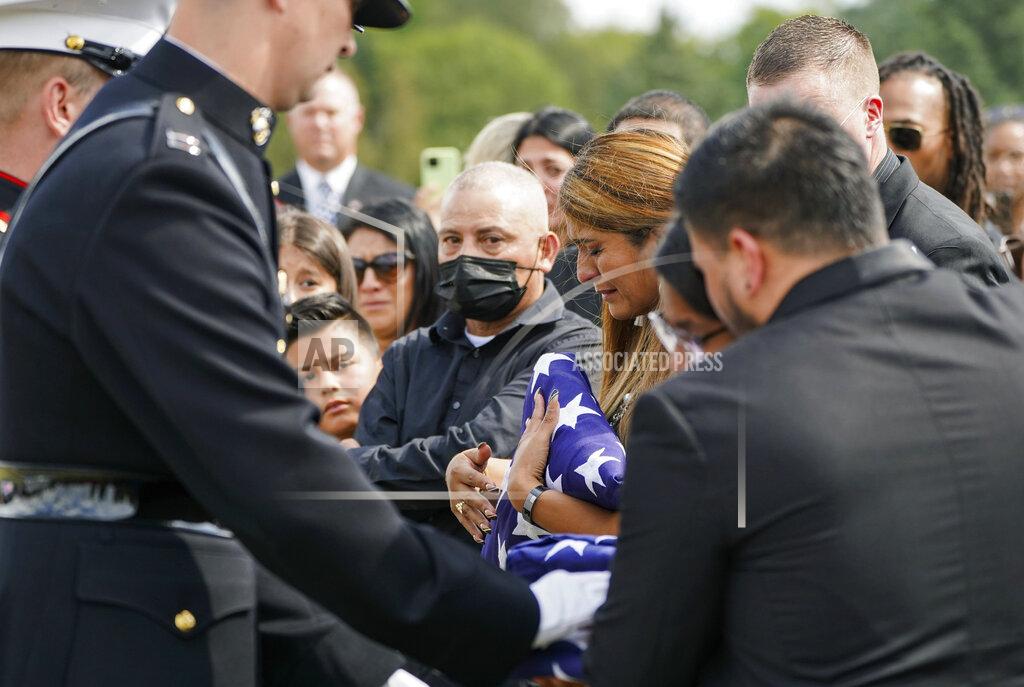 Jonah Hinebaugh The family of Marine Cpl. Humberto Sanchez are presented folded flags during the graveside service at Mount Hope Cemetery in Logansport, Ind., on Tuesday, Sept. 14, 2021. Sanchez was one of 13 U.S. service members killed in last month's suicide bombing at Afghanistan’s Kabul airport during the U.S.-led evacuation. (Jonah Hinebaugh/The Pharos-Tribune via AP)