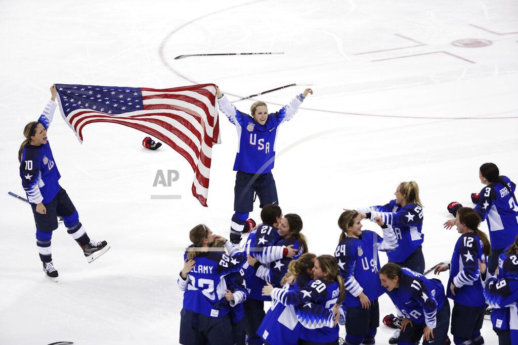 Matt Slocum FILE - In this Feb. 22, 2018, file photo, Meghan Duggan (10), of the United States, and Monique Lamoureux-Morando (7), also of the United States, celebrate with teammates after defeating Canada in the women's gold medal hockey game at the Winter Olympics in Gangneung, South Korea. U.S. women's hockey captain Duggan announced her retirement Tuesday, Oct. 13, 2020, after a career in which she won the 2018 Olympic gold medal and seven world championship golds. (AP Photo/Matt Slocum, File)