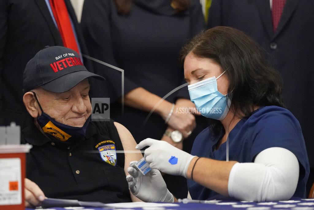 Wilfredo Lee Registered Nurse Katherine Pachota, right, prepares to inoculate Bay of Pigs invasion veteran Rigoberto Montesinos, 82, during a news conference, Monday, Feb. 8, 2021, at the Bay of Pigs Museum and Library in the Little Havana neighborhood of Miami. Montesinos was frustrated his first vaccine appointment was inexplicably canceled, but he finally got his first dose Monday. Montesinos said he worried about side effects, but "at my age, and with the virus spiking, I can't be putting myself at risk." (AP Photo/Wilfredo Lee)
