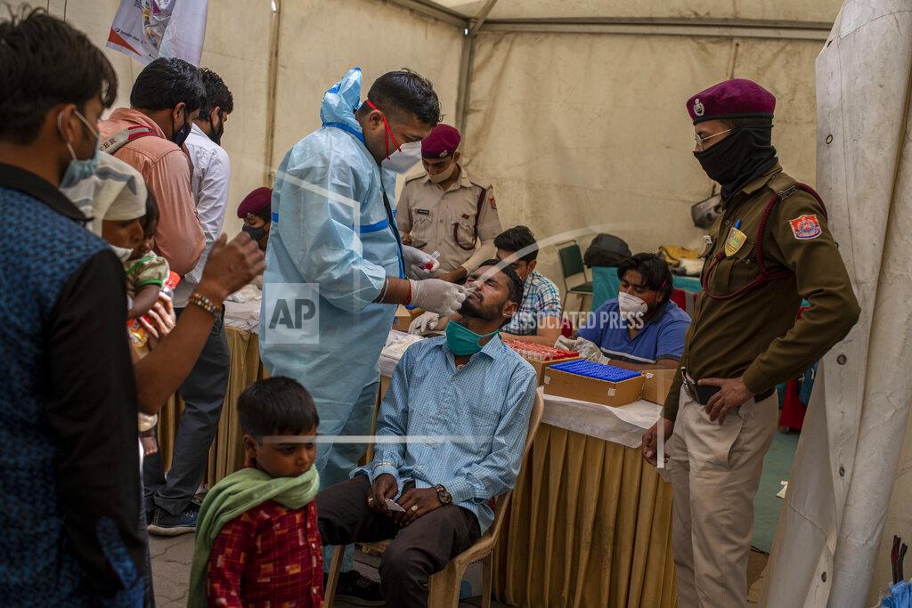 Altaf Qadri A health worker takes a nasal swab sample of a passenger to test for COVID-19 at a bus terminal in New Delhi, India, Wednesday, March 24, 2021. (AP Photo/Altaf Qadri)