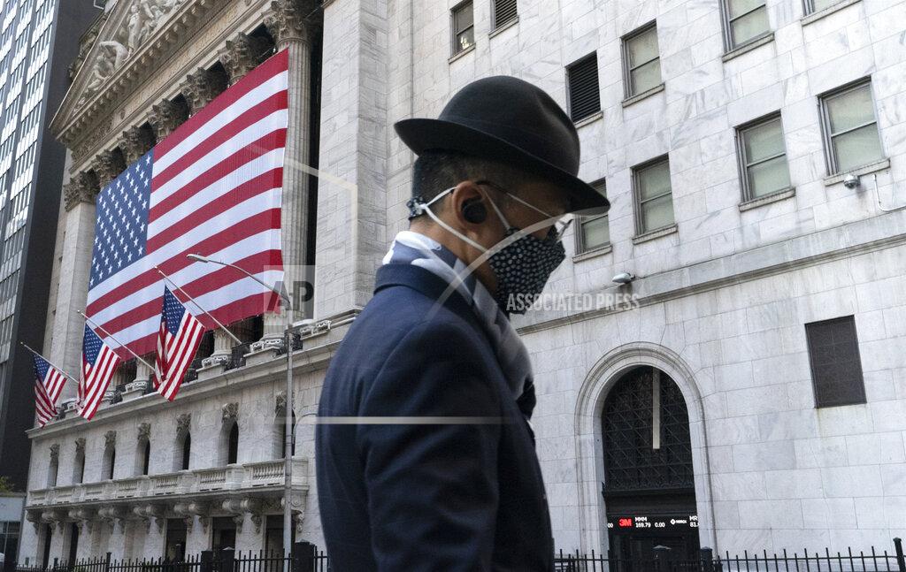 FILE - In this Nov. 16, 2020 file photo a man wearing a mask passes the New York Stock Exchange in New York. Stocks are moving modestly higher in early trading on Wall Street as investors cautiously welcome signs of calm in the bond market. The S&P 500 was up 0.4% early Thursday, March 4, 2021, and the yield on the 10-year Treasury held steady at 1.47%. (AP Photo/Mark Lennihan, File)
