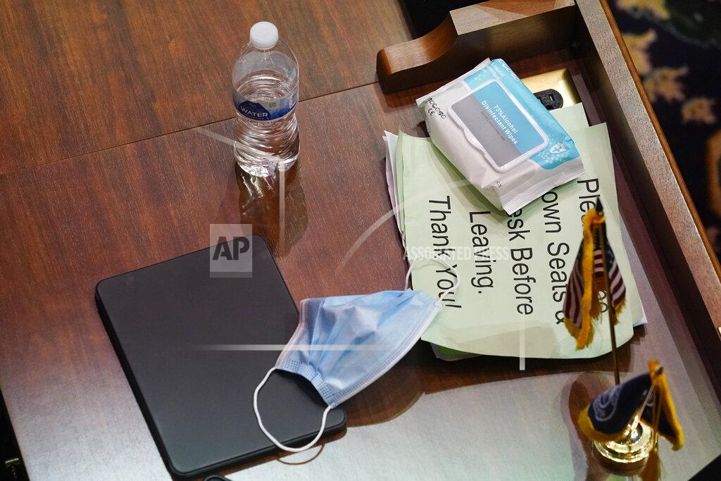 Darron Cummings A mask and disinfection wipes are at the desk of a representative as they meet at the Statehouse, Thursday, April 22, 2021, in Indianapolis. (AP Photo/Darron Cummings)