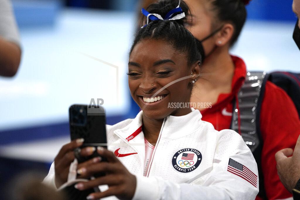 Ashley Landis Simone Biles, of the United States, talks on the phone after participating on the balance beam during the artistic gymnastics women's apparatus final at the 2020 Summer Olympics, Tuesday, Aug. 3, 2021, in Tokyo, Japan. (AP Photo/Ashley Landis)