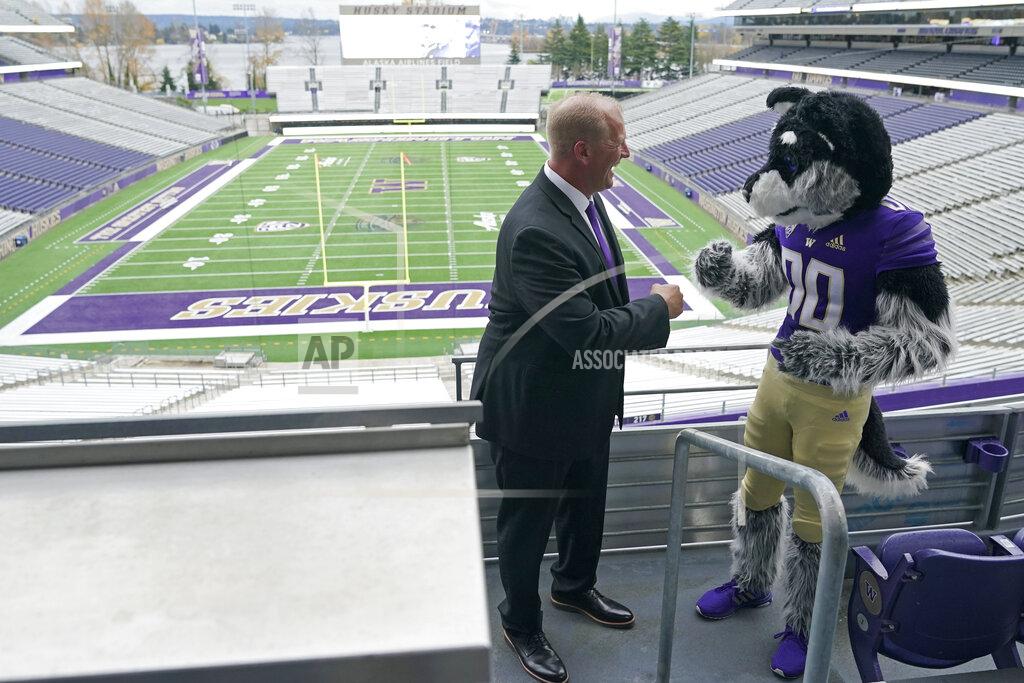 Ted S. Warren Kalen DeBoer reacts after posing for a photo with Harry, the Washington mascot, Tuesday, Nov. 30, 2021, at Husky Stadium, following a news conference in Seattle to introduce DeBoer as the new head NCAA college football coach at the University of Washington. DeBoer has spent the past two seasons as head football coach at Fresno State. (AP Photo/Ted S. Warren)