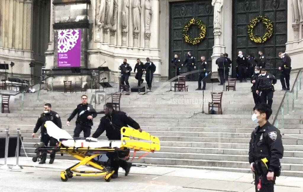 Ted Shaffrey Emergency medical personnel pull a stretcher up to the scene of a shooting at the Cathedral Church of St. John the Divine, Sunday, Dec. 13, 2020, in New York. A man was shot by police after shots rang out at the end of a Christmas choral concert on the steps of the Manhattan cathedral Sunday afternoon. The shooting happened just before 4 p.m. at the church which is the mother church of the Episcopal Diocese of New York and seat of its bishop. (AP Photo/Ted Shaffrey)