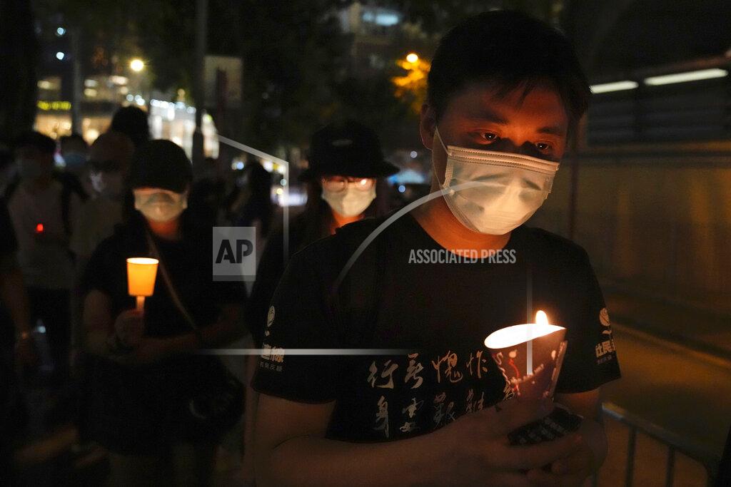 Kin Cheung People walk with candles to mark the anniversary of the military crackdown on a pro-democracy student movement in Beijing, outside Victoria Park in Hong Kong, Friday, June 4, 2021. A member of the committee that organizes Hong Kong's annual candlelight vigil for the victims of the Tiananmen Square crackdown was arrested early Friday on the 32nd anniversary. (AP Photo/Kin Cheung)