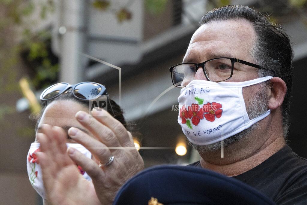 Mark Baker Spectators watch as veterans march during the Anzac Day parade in Sydney, Australia, Sunday, April 25, 2021. Australians and New Zealanders paid tribute to their war dead Sunday as both nations prepared to withdraw from their longest war in Afghanistan. (AP Photo/Mark Baker)