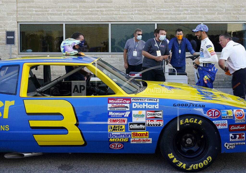 Eric Gay McLaren driver Daniel Ricciardo, of Australia, second from right, prepares to drive the late Dale Earnhardt's iconic 1984 No. 3 Wrangler Chevrolet Monte Carlo before an open practice for the Formula One U.S. Grand Prix auto race at the Circuit of the Americas, Saturday, Oct. 23, 2021, in Austin, Texas. Ricciardo was allowed to drive the car as a reward from his McLaren boss, Zak Brown, for winning his first race with the team. (AP Photo/Eric Gay)