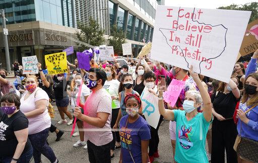 FILE - In this Oct. 2, 2021 file photo people participate in the Houston Women's March against Texas abortion ban walk from Discovery Green to City Hall in Houston. A federal appeals court is temporarily allowing the nation’s toughest abortion law to resume in Texas. The 5th U.S. Circuit Court of Appeals handed down the order Friday, Oct. 8. (Melissa Phillip/Houston Chronicle via AP, File)