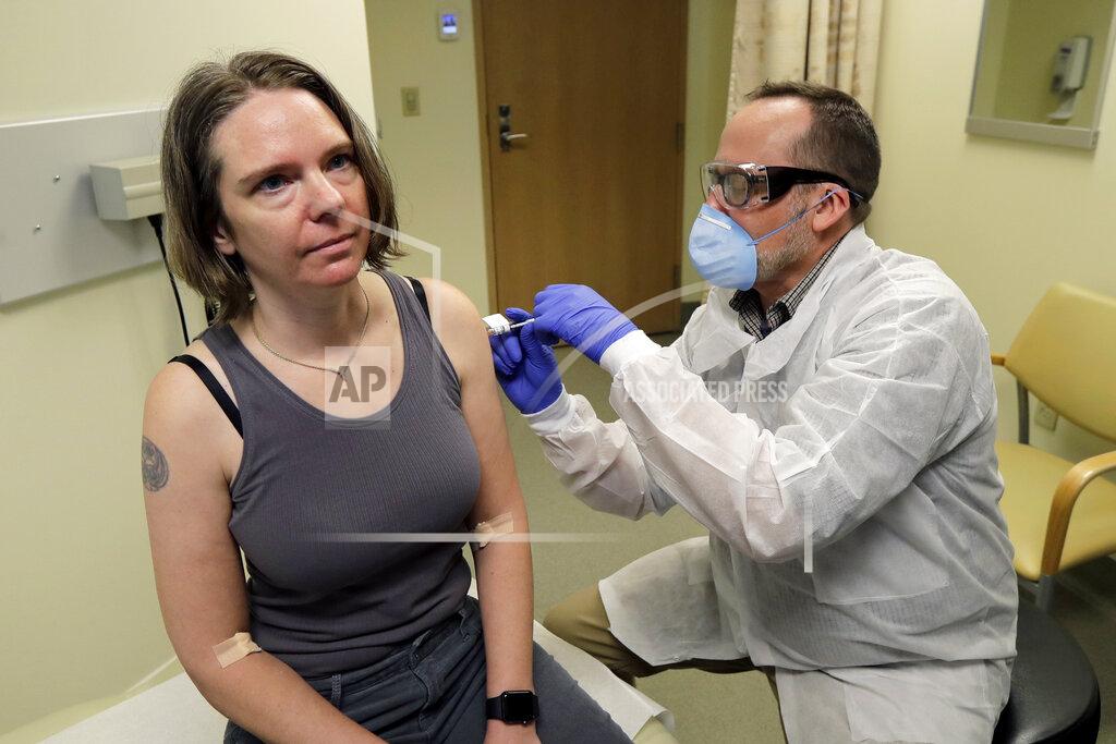Ted S. Warren FILE - In this March 16, 2020 file photo, a pharmacist gives Jennifer Haller, left, the first shot in the first-stage safety study clinical trial of a potential vaccine for COVID-19, the disease caused by the new coronavirus, at the Kaiser Permanente Washington Health Research Institute in Seattle. The world's biggest COVID-19 vaccine test got underway Monday, July 27 with the first of 30,000 planned volunteers. The experimental vaccine is made by the National Institutes of Health and Moderna Inc., and it's one of several candidates in the final stretch of the global vaccine race. (AP Photo/Ted S. Warren, File)