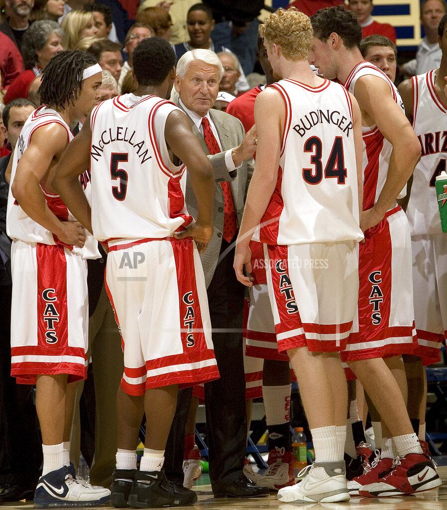 John Miller FILE - In this Dec. 20, 2006, file photo, Arizona head coach Lute Olson, center, talks to his players, from left to right, Daniel Dillon, Jawann McClellan (5), Chase Budinger (34) and Ivan Radenovic during the second half of a college basketball game against Memphis in Tucson, Ariz. Olson, the Hall of Fame coach who turned Arizona into a college basketball powerhouse, has died at the age of 85. Olson’s family said he died Thursday, Aug. 27, 2020. The family did not provide the cause of death. (AP Photo/John Miller, File)