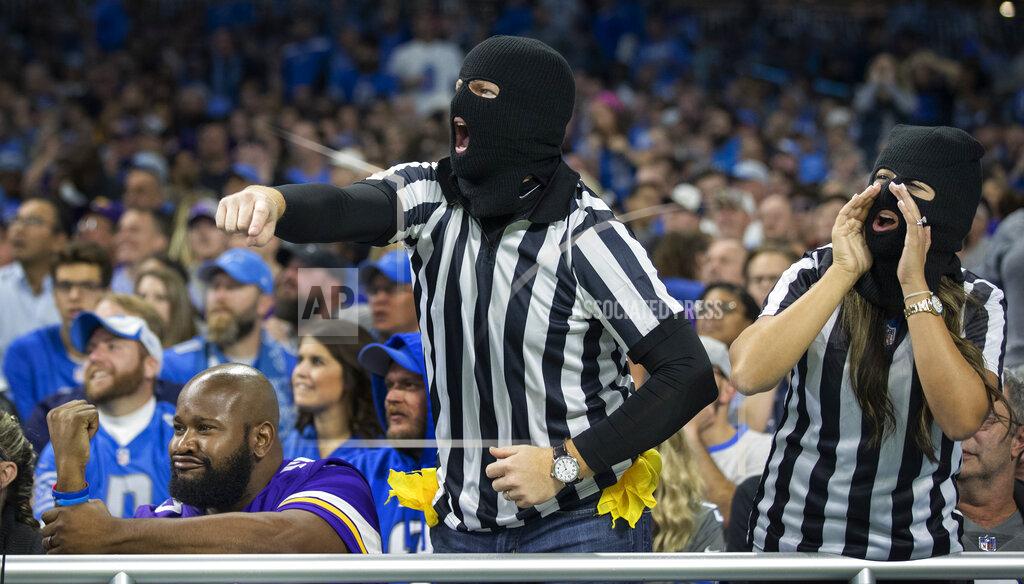 Jerry Holt Minnesota Vikings fan Ryan Weche, of Boston, seated at left, and Detroit Lions fans Andrew DeHaan and his wife, Stephanie DeHann, of Detroit, react to a call in the second quarter of an NFL football game, Sunday, Oct. 20, 2019, in Detroit. (Jerry Holt/Star Tribune via AP)