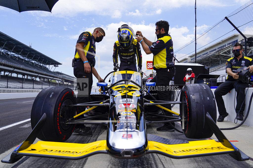 Michael Conroy Zach Veach climbs into his car during practice for the Indianapolis 500 auto race at Indianapolis Motor Speedway in Indianapolis, Friday, Aug. 14, 2020. (AP Photo/Michael Conroy)