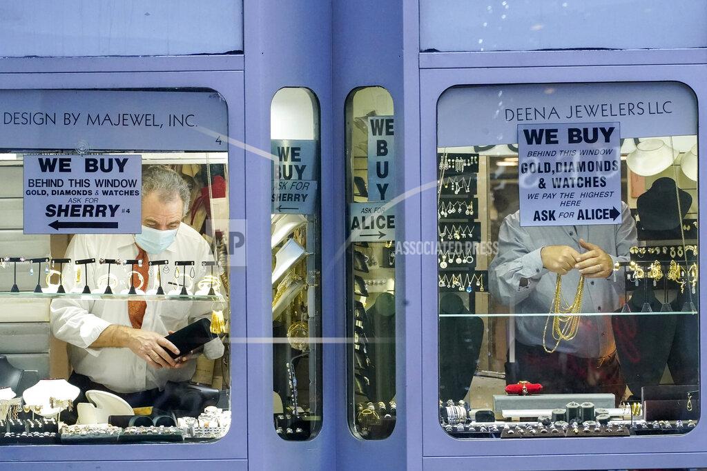Mary Altaffer A couple of jewelers stock their windows before opening for Black Friday shoppers along Fifth Avenue, Friday, Nov. 27, 2020, in New York. (AP Photo/Mary Altaffer)