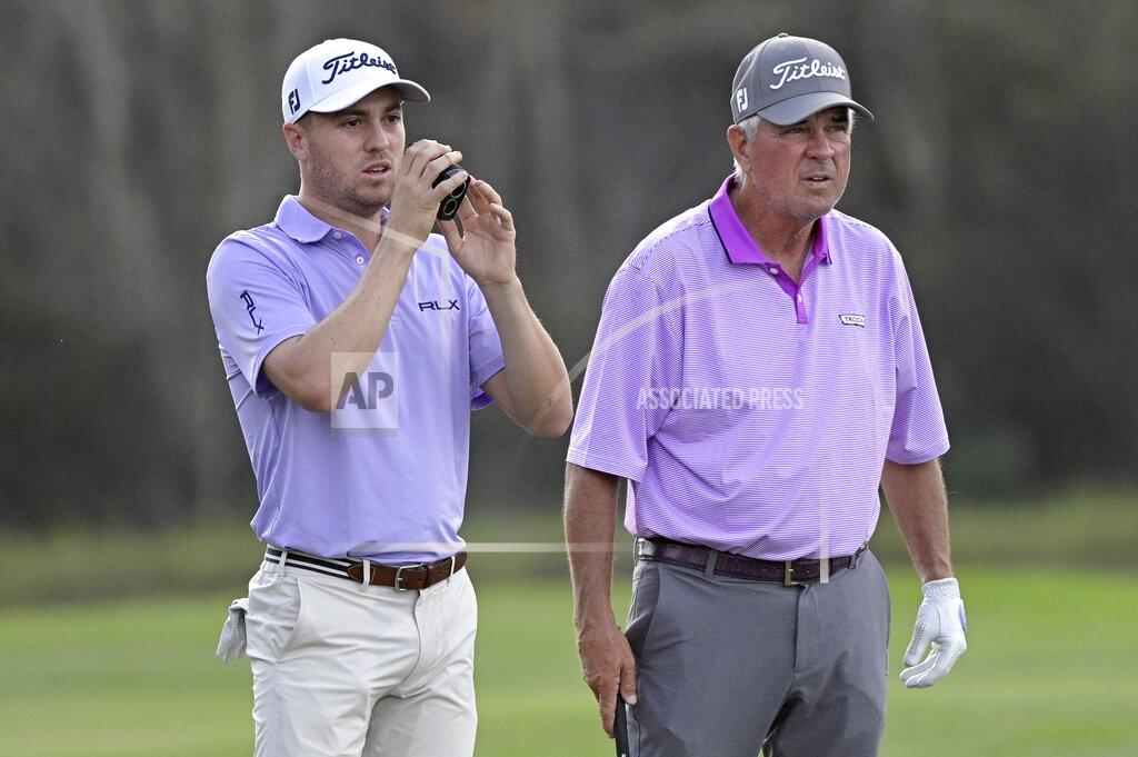 Phelan M. Ebenhack Justin Thomas, left, and his father Mike Thomas check the distance of their shot from the 14th fairway during the first round of the PNC Championship golf tournament, Saturday, Dec. 19, 2020, in Orlando, Fla. (AP Photo/Phelan M. Ebenhack)