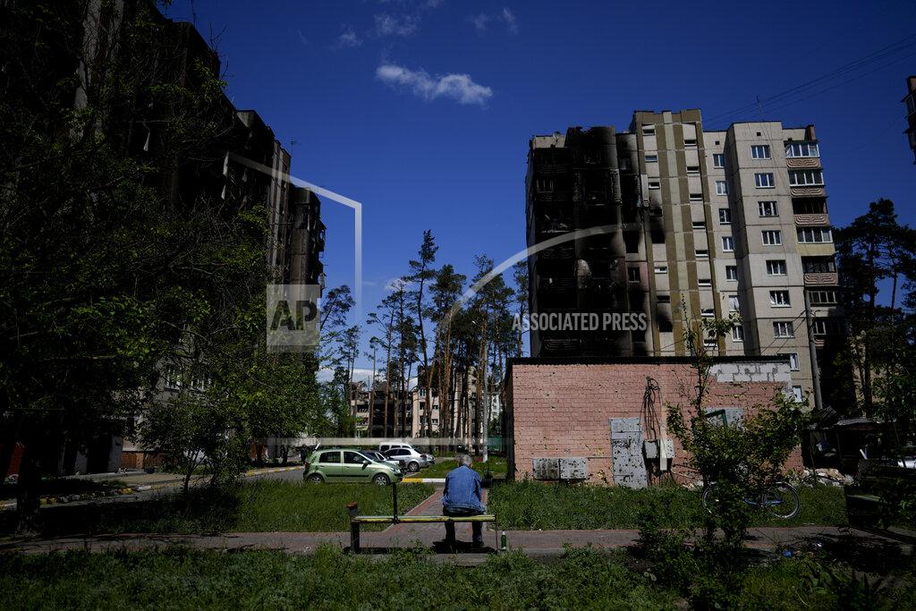 Natacha Pisarenko A resident sits outside buildings damaged by shelling in Irpin, outskirts of Kyiv, Ukraine, Tuesday, May 24, 2022. (AP Photo/Natacha Pisarenko)