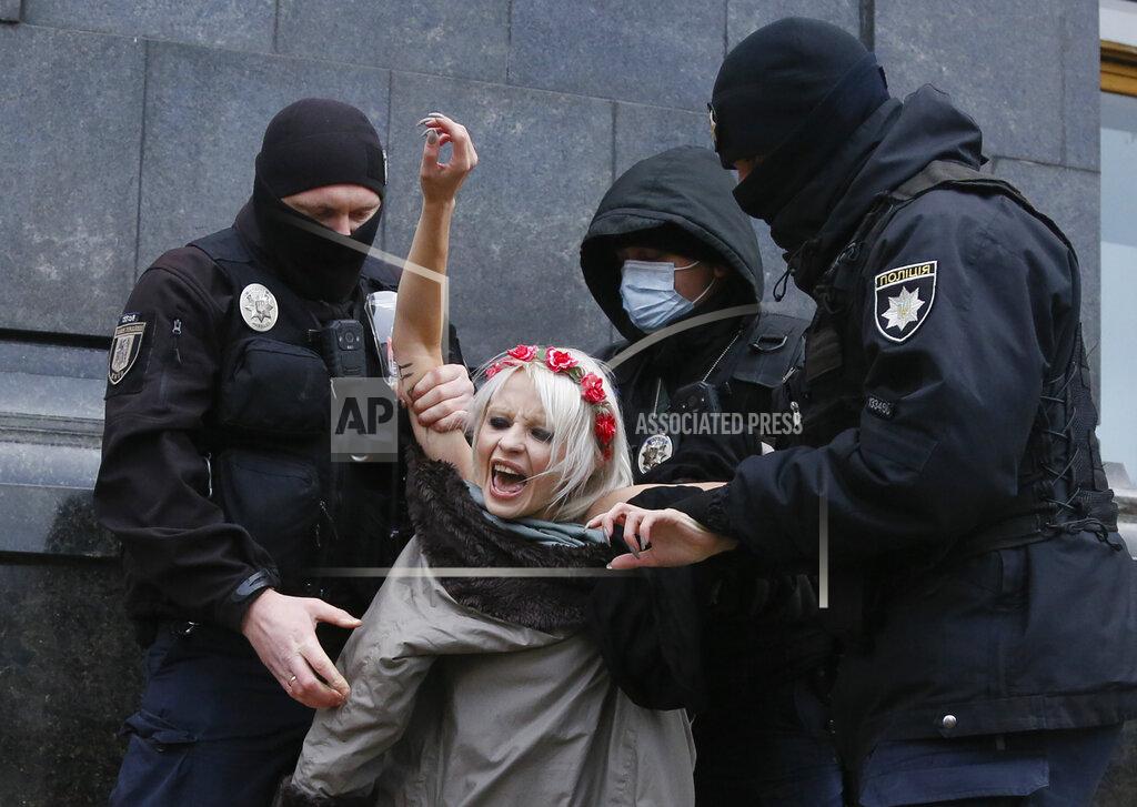 Efrem Lukatsky Police detain an activist from Ukrainian female rights organization "Femen" on the International Day for the Elimination of Violence against Women as she protested naked in front of the Presidential Office in Kyiv, Ukraine, Wednesday, Nov. 25, 2020. Femen is demanding the Ukrainian authorities to ratify the Istanbul Convention on the protection of women. (AP Photo/Efrem Lukatsky)