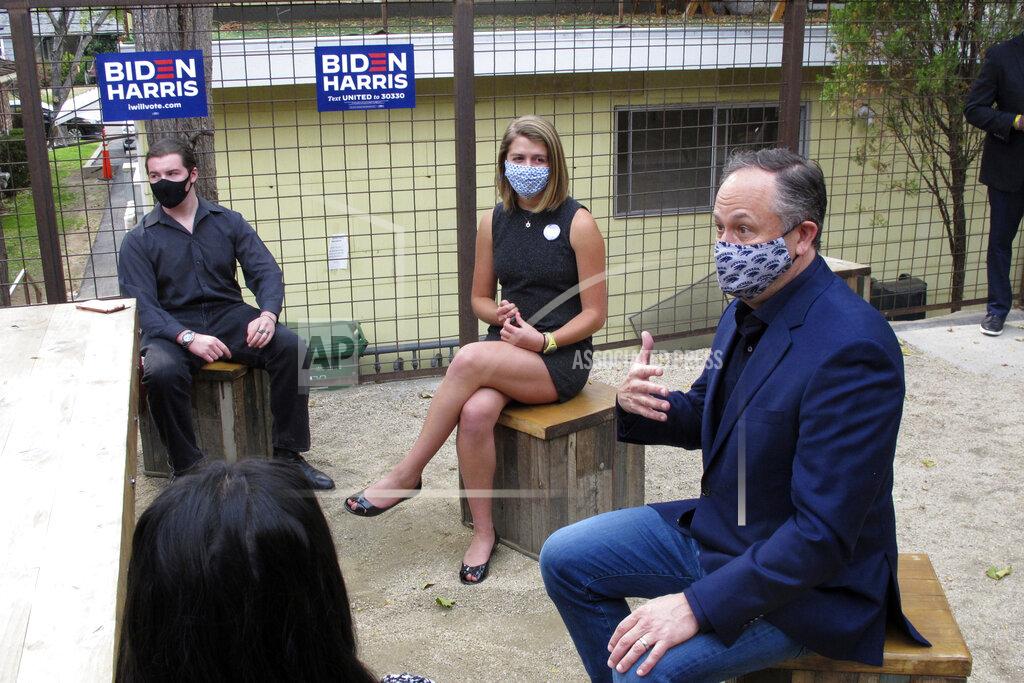 Doug Emhoff, husband of Democratic vice presidential nominee Kamala Harris, dons a Nevada Wolf Pack mask as he speaks to university students during a roundtable on the patio of a coffee shop on Thursday Oct. 8, 2020, in Reno, Nev. Emhoff said the debate the night before between his wife and Vice President Mike Pence showed the stark contrast between the party's philosophies, including the compassion a Biden-Harris ticket would bring to a White House that currently shows none for COVID-19 victims. (AP Photo/Scott Sonner).