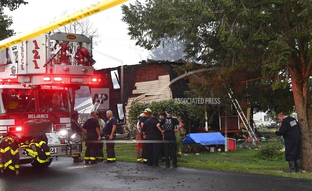 Jimmy May Firefighters gather next to a home after an early morning fatal fire at 733 First Street in Nescopeck, Pa., Friday, Aug. 5, 2022. The fire was reported around 2:30 a.m. The cause of the fire remains under investigation. (Jimmy May/Bloomsburg Press Enterprise via AP)