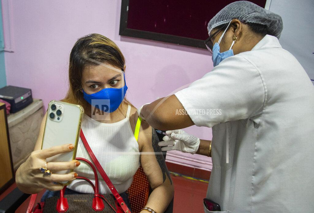Anupam Nath FILE - In this May 17, 2021, file photo, a woman takes selfie as she receives a vaccine for COVID-19 in Gauhati, Assam, India. The disparities of the coronavirus pandemic were already stark in India, where access to health care is as stratified and unequal as other parts of its society. Now, the divide along the lines of wealth and technology are further widening that chasm, and many people are falling through the gaps as vaccines remain inaccessible to millions. (AP Photo/Anupam Nath, File)