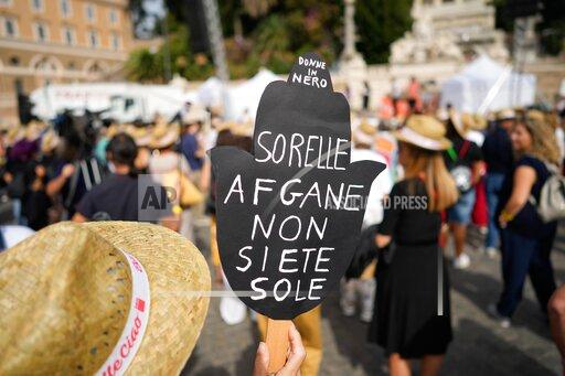 A woman holds a banner reading "Afghan sisters you're not alone" during a demonstration in favor of Afghan women's rights, staged by women rights activists, in Rome, Saturday, Sept. 25, 2021. (AP Photo/Andrew Medichini)