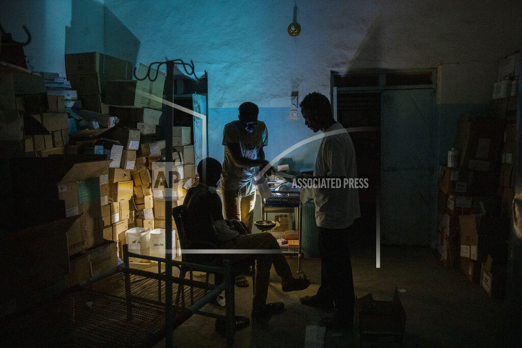 Nariman El-Mofty Surgeon and doctor-turned-refugee, Dr. Tewodros Tefera, checks a Tigrayan refugee inside the Sudanese Red Crescent clinic, at Hamdayet Transition Center near the Sudan-Ethiopia border, eastern Sudan, on March 23, 2021. Tewodros fills a growing number of notebooks as he compiles a “dossier” on the Tigray conflict. Sometimes he dreams of taking it to the International Criminal Court in a quest for justice. (AP Photo/Nariman El-Mofty)