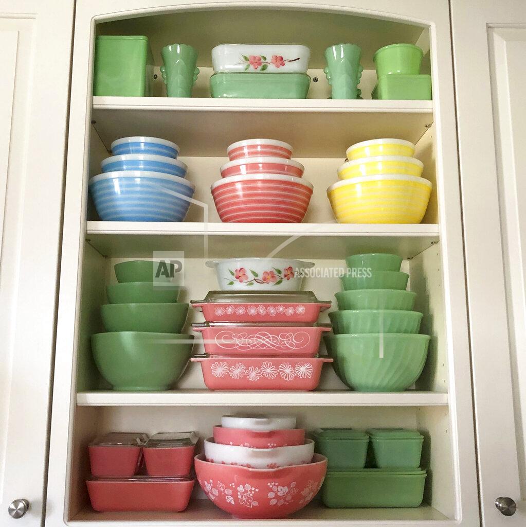 Lauren Mccullough Vintage pieces of Pyrex and Fire-King, as well as jadeite glass produced by Fire King and McKee appear in a kitchen cupboard in Lynbrook, N.Y. Vintage kitchenware is back in style -– pieces from the mid-20th century painted with flowers, bright colors, and specific functions, such as bracketed chip and dip bowls or four-piece refrigerator storage sets. (Lauren McCullough via AP)