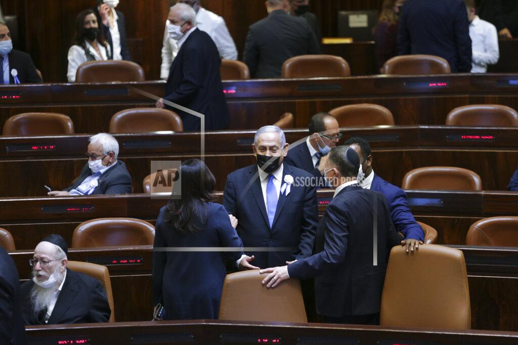 Alex Kolomoisky Israeli Prime Minister Benjamin Netanyahu, center, speaks with Knesset members during the swearing-in ceremony for Israel's 24th government, at the Knesset, or parliament, in Jerusalem, Tuesday, April 6, 2021. The ceremony took place shortly after the country's president asked Netanyahu to form a new majority coalition, a difficult task given the deep divisions in the fragmented parliament. (Alex Kolomoisky/Pool via AP)
