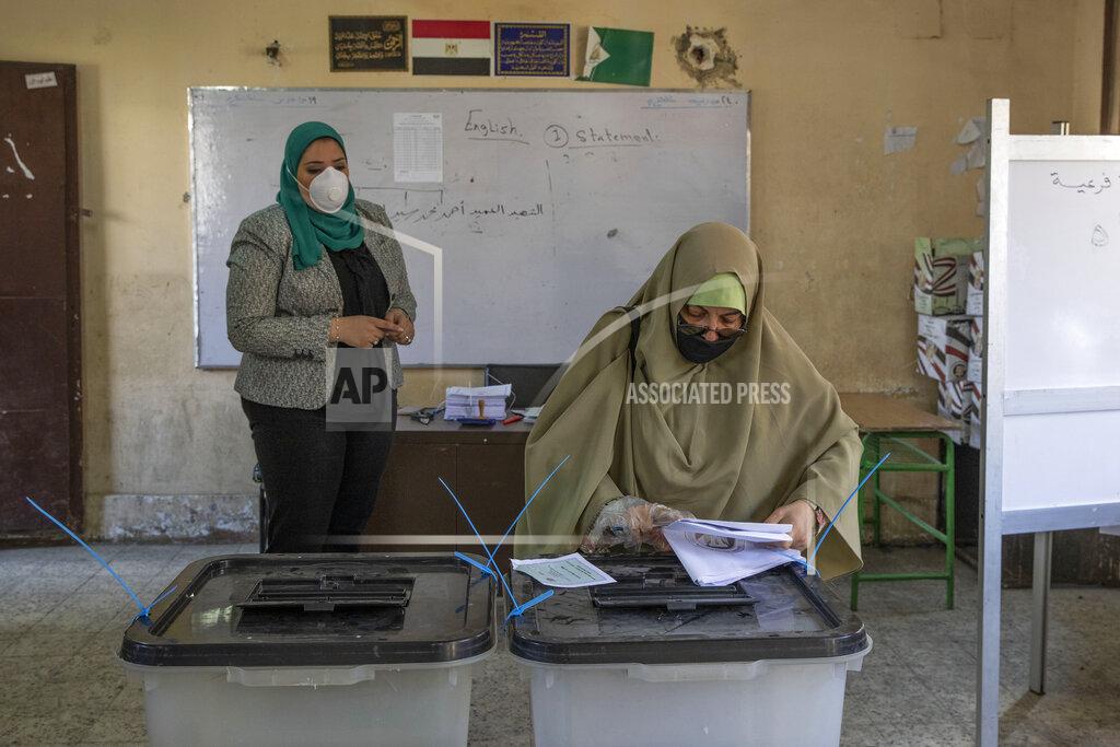 Nariman El-Mofty A woman casts her ballot on the first day of the Senate elections inside a polling station in Cairo, Egypt, Tuesday, Aug. 11, 2020. Egyptians started voting on Tuesday for the Senate, the upper chamber of parliament that was revived as part of constitutional amendments approved in a referendum last year — an election that comes as the country faces an uptick in daily numbers of new coronavirus cases. (AP Photo/Nariman El-Mofty)