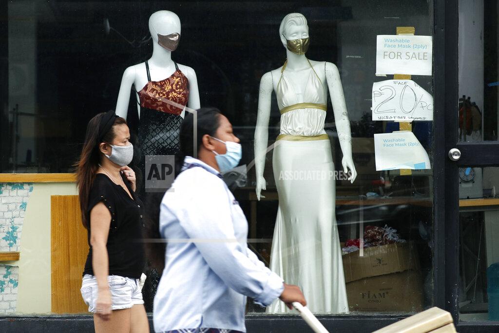 Aaron Favila FILE - In this Sept. 29, 2020, file photo, women walk past mannequins wearing face masks advertised for sale, at a shop in Makati city, Philippines. Developing economies in Asia will likely grow at a slower pace than earlier expected due to prolonged COVID-19 outbreaks and uneven progress in vaccinations, the Asian Development Bank said in a report Wednesday, Sept. 22, 2021.(AP Photo/Aaron Favila, File)