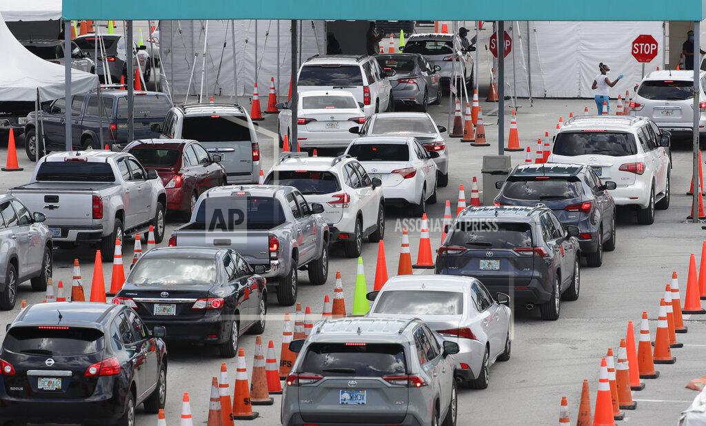 Wilfredo Lee Vehicles wait in line at a drive-thru COVID-19 testing site outside Hard Rock Stadium, Wednesday, July 8, 2020, in Miami Gardens, Fla. Florida is one of the nation's hot spots for coronavirus. Almost 10,000 confirmed cases were added Wednesday, bringing its total since March 1 to nearly 224,000. Almost 4,000 people have died, including 48 reported by the state Wednesday. (AP Photo/Wilfredo Lee)