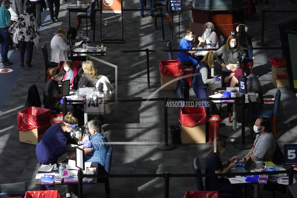 Steven Senne FILE - In this Feb. 11, 2021, file photo, people are administered COVID-19 vaccines at a vaccination center, at Gillette Stadium, in Foxborough, Mass. The U.S. death toll from COVID-19 has almost topped 500,000 — a number so staggering that a top health researchers says it is hard to imagine an American who hasn't lost a relative or doesn't know someone who died. (AP Photo/Steven Senne, File)