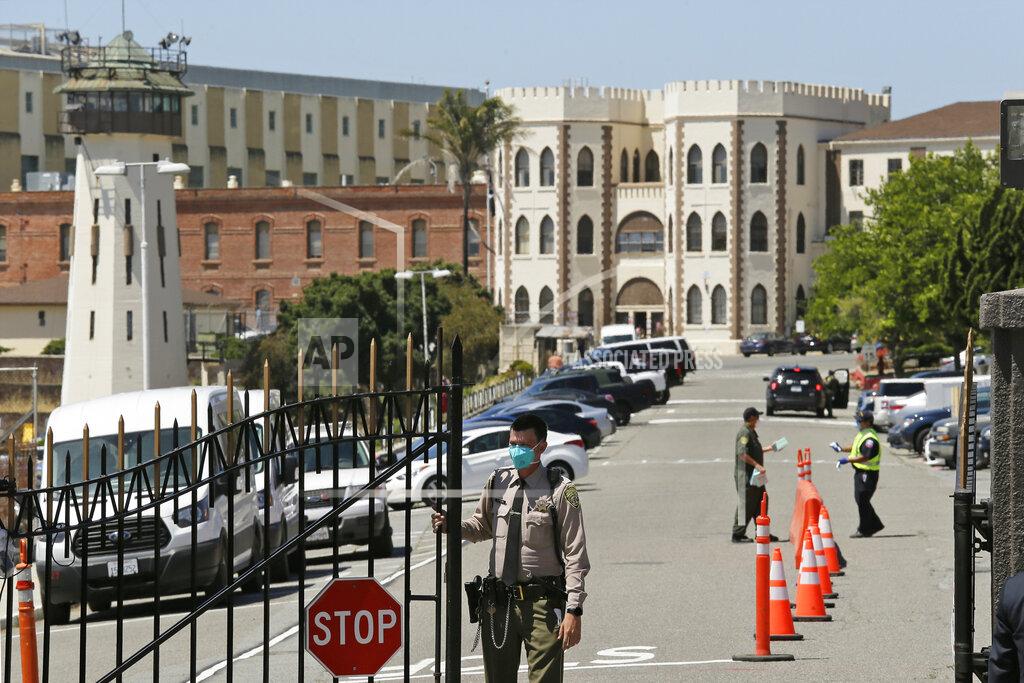 Eric Risberg FILE - In this July 9, 2020 file photo, a correctional officer closes the main gate at San Quentin State Prison in San Quentin, Calif. A California appeals court has ordered state corrections officials to cut the population of one of the world's most famous prisons to less than half of its designed capacity, citing officials' "deliberate indifference" to the plight of inmates during the coronavirus pandemic. State prison officials said Wednesday, Oct. 21, 2020, that they are deciding whether to appeal the order, which otherwise will force them to parole or transfer about 1,100 inmates serving time in San Quentin State Prison north of San Francisco. (AP Photo/Eric Risberg, File)