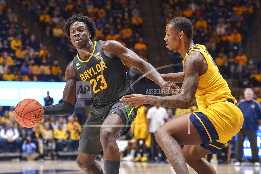William Wotring Baylor forward Jonathan Tchamwa Tchatchoua (23) protects the ball from West Virginia forward Gabe Osabuohien (3) during the second half of an NCAA college basketball game in Morgantown, W.Va., Tuesday, Jan. 18, 2022. (William Wotring)