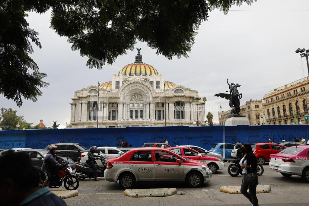 Rebecca Blackwell Pedestrians and cars pass in front of the Palace of Fine Arts amidst the "new normal" of the ongoing coronavirus pandemic, in central Mexico City, Monday, Aug. 10, 2020. (AP Photo/Rebecca Blackwell)